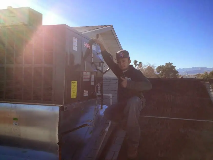 HVAC technician performing AC Tune-Up on a rooftop unit in South Haven